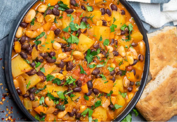cajun bean and potato stew served in a dish next to squares of cornbread