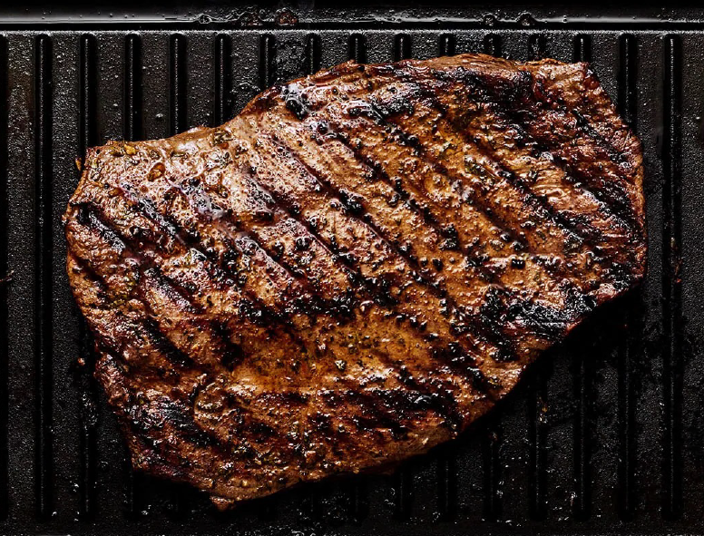 carne asada, barbecued beef, presented on a griddle