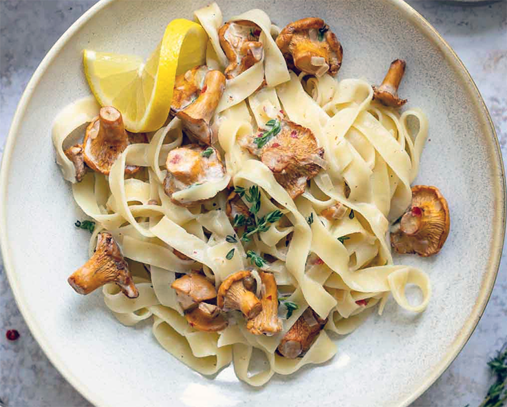 chanterelle mushrooms, bacon and mascarpone sauce shown mixed with tagliatelle pasta