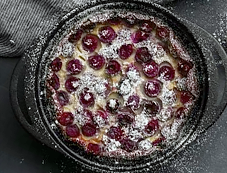 black cherry clafoutis baked in a glass casserole dish