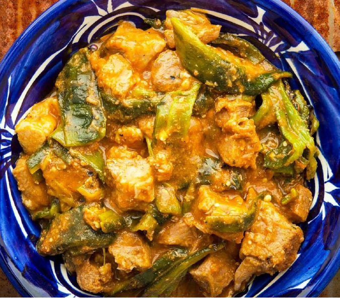 Chilaca pork and chilli stew with tomatillos served in  blue bowl