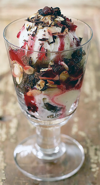 Christmas dessert sundae with christmas pudding ice cream, cranberry sauce and chocolate served in a sundae glass