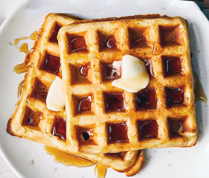 waffles made with cocoyam flour on a plate drizzled with syrup