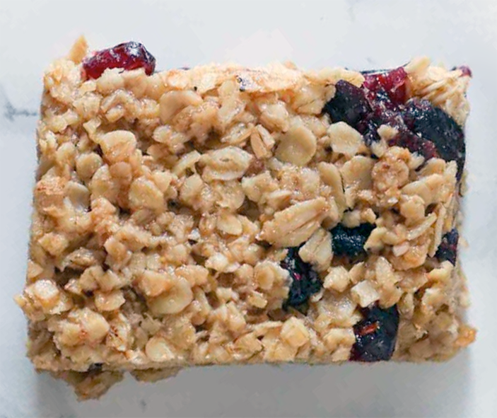 rectangle of cranberry flapjack on a marble slab