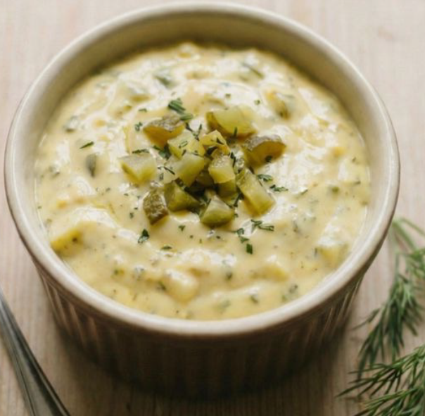 Danish curry remoulade sauce in a ramekin garnished with chopped pickled gherkin