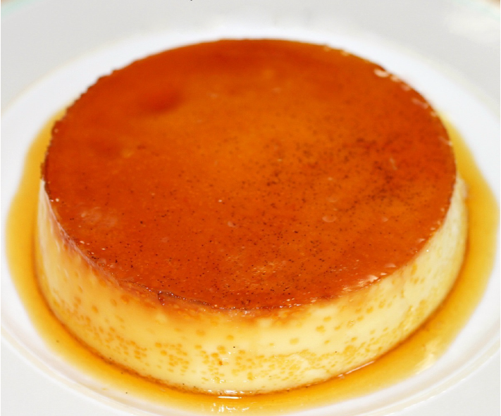Flan Mexicano inverted onto a serving plate surrounded by caramel