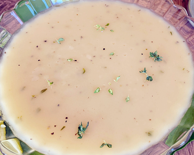 dessert white wine and melted butter sauce in a fluted glass bowl garnished with grated lime zest