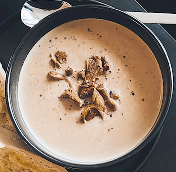 golden chanterelle soup served in a bowl with a garnish of fried chanterelles