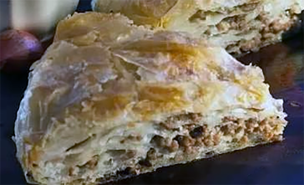 wedge of layered gollash meat pie on a plate