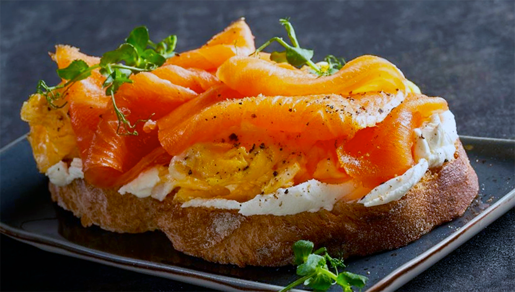Danish open sandwich of rye bread, butter, mayonnaise, pickles, seasoned smoked salmon and micro greens