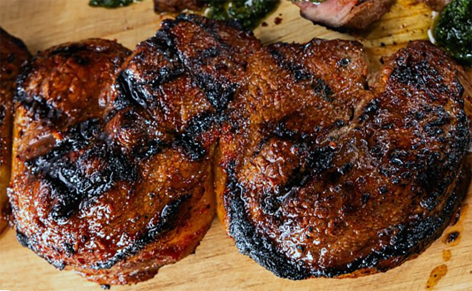 beef steaks griddled after marinating in adobo sauce presented on a wooden block