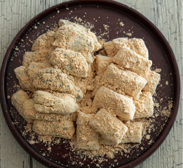 injeolmi, sweet rice cakes on a plate dusted with roasted soybean powder