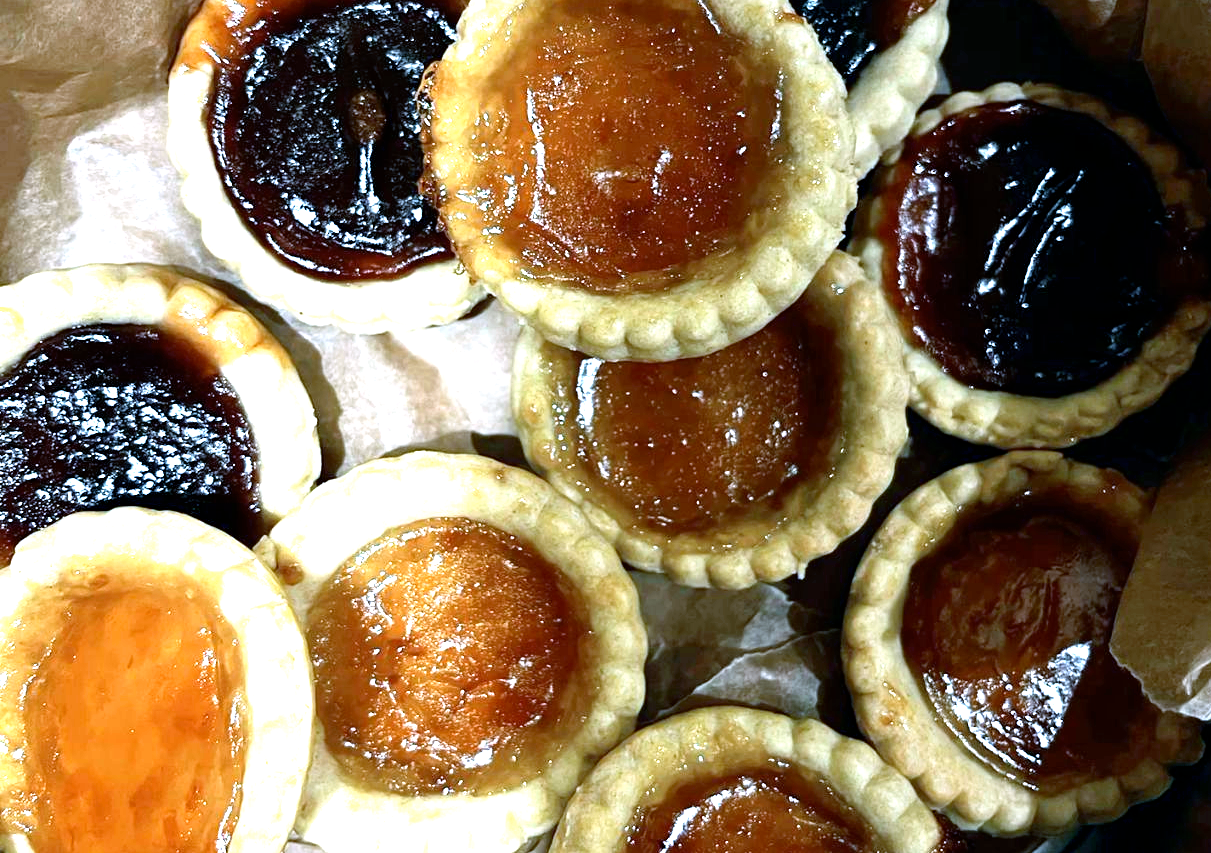 jam tarts with different jams piled in a cake tin