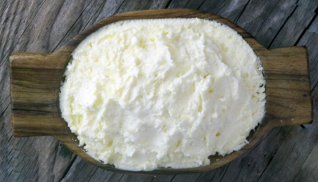 Kajmak cream cheese on a wooden butter tray