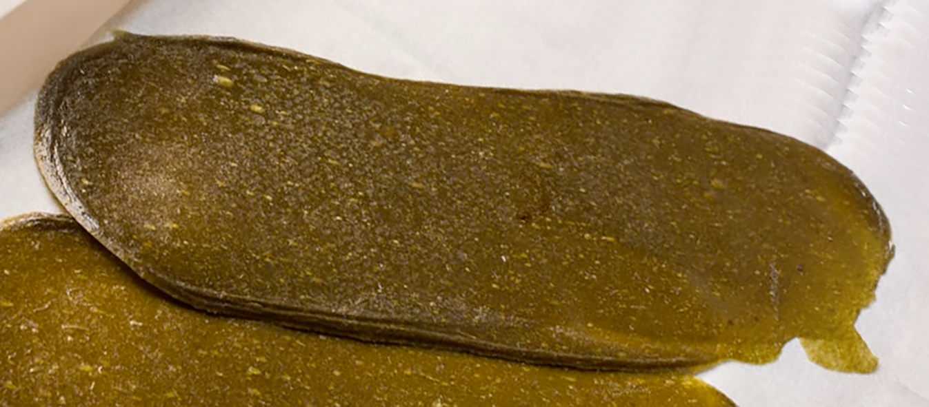 two overlapping sheets of japanese knotweed and apple leather on a tile counter top
