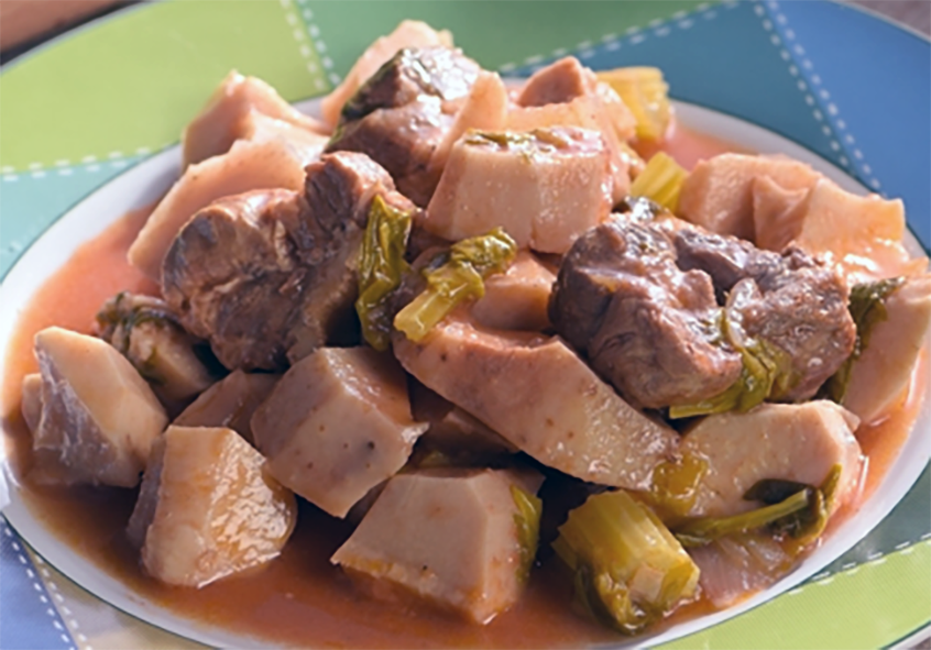 kolkasi, stew of taro and pork in a tomato base served in a dish