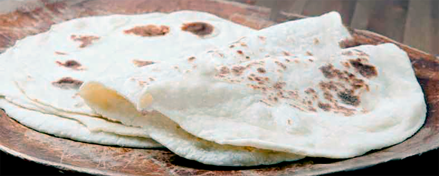 five turkish cypriot lavas flatbread shown on a wooden plate with two folded in half