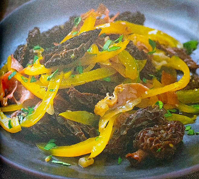 morels fried with yellow bell pepper slices served on a blue plate