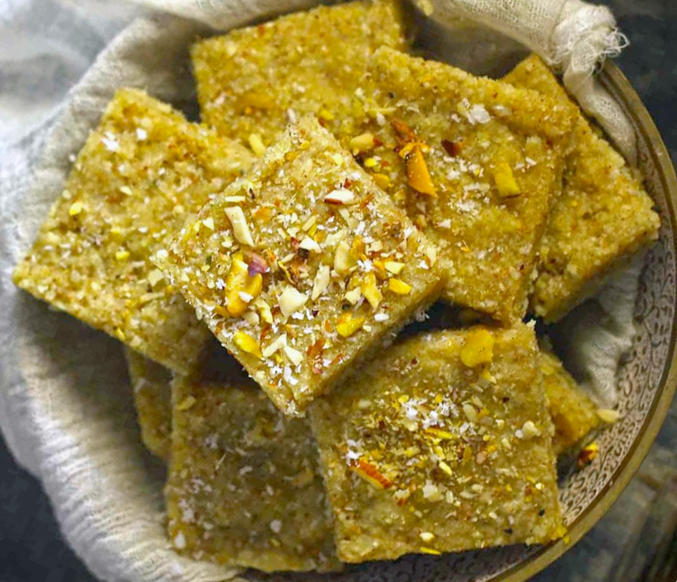 squares of panjeeri piled in a wooden bowl