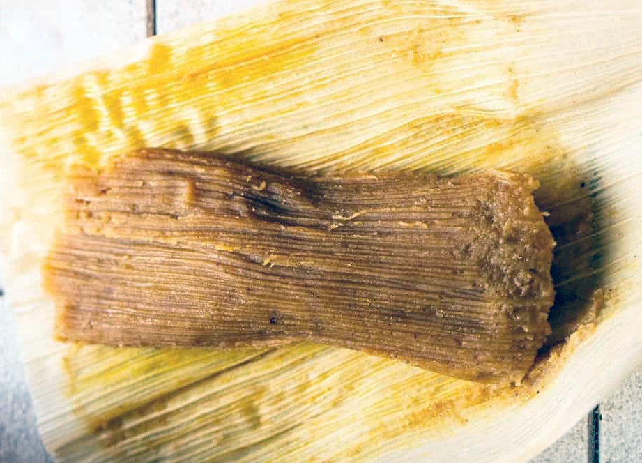single pumpkin and chanterelle tamale on an unwrapped maize husk
