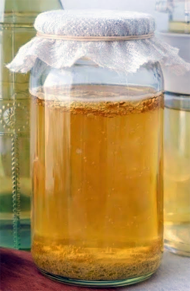 Raw cider vinegar with developing mother in a jar covered with muslin