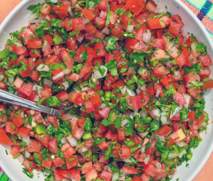 salsa bandera of chopped tomatoes, onion, serrano chilli and coriander served on a plate
