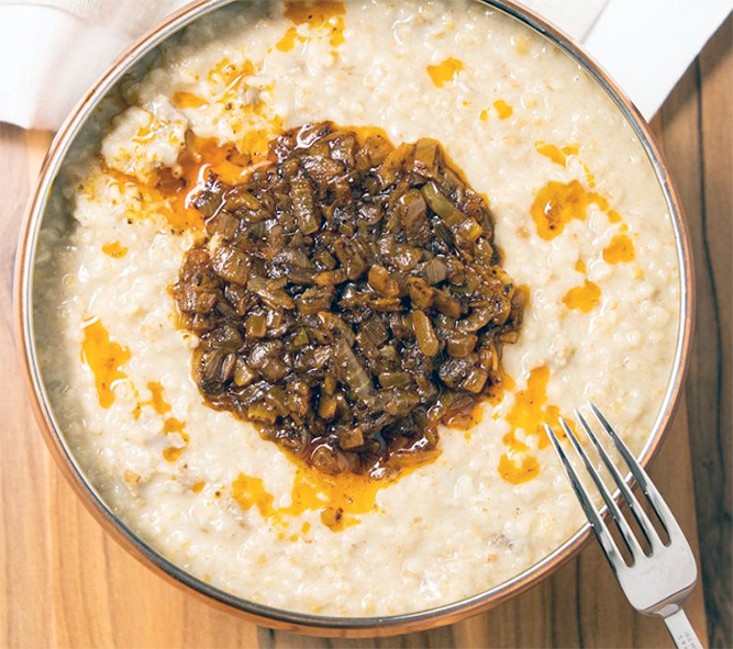 saudi wheat jareesh served in a bowl with a spice and onion topping
