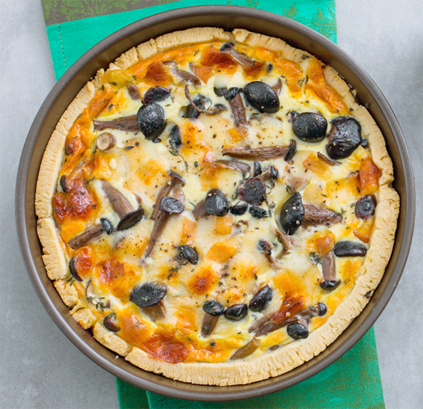 savoury honey fungus tart in a metal tart tin on a piece of green tablecloth