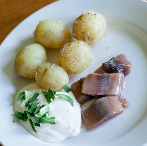 pickled herring served with boiled new potatoes and sour cream
