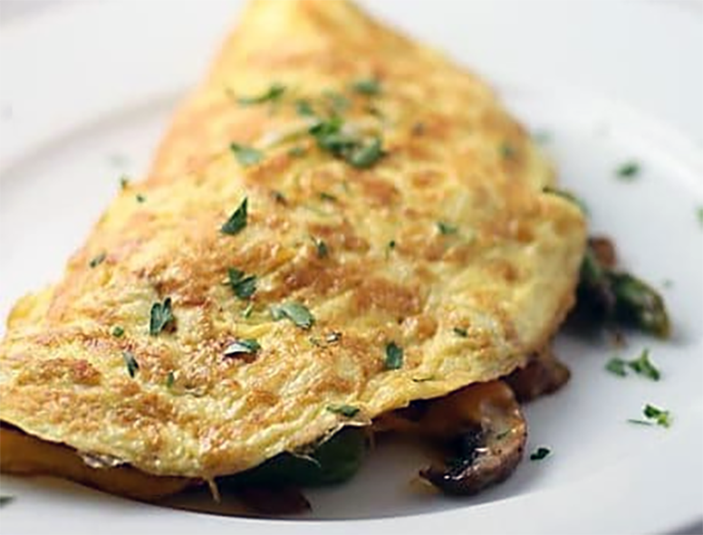 folded omelette garnished with thyme leaves with an asparagus and St George's mushroom filling