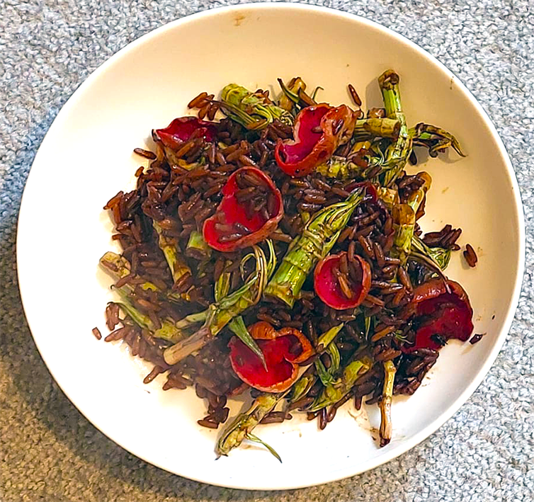 stir fry of japanese knotweed tips, onion and scarlet elfcups in a white dish