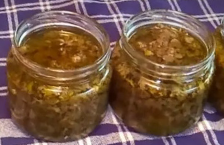 Two uncovered jars filled with summer truffle paste on a blue check tablecloth