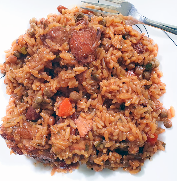 Trinidadian  chicken pelau served on a plate with a fork