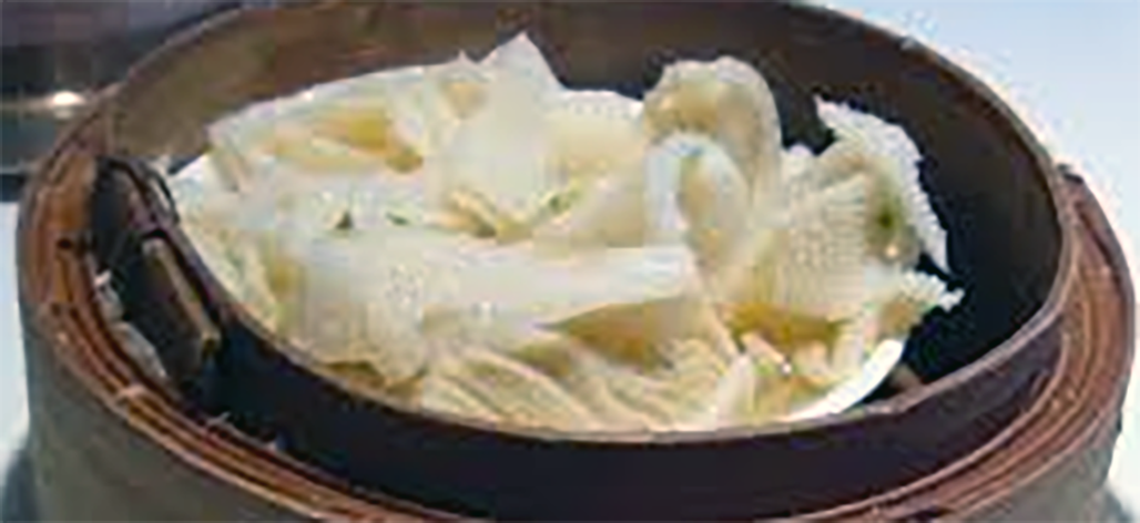 tripe with tatties served in a bowl held in a bamboo steamer