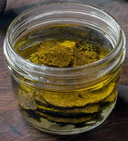 slices of summer truffle in oil within a glass jar