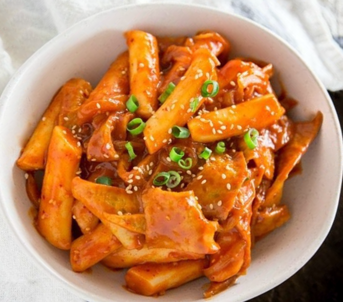 Spicy Korean cylinder rice cakes in a gochujang sauce served in a bowl