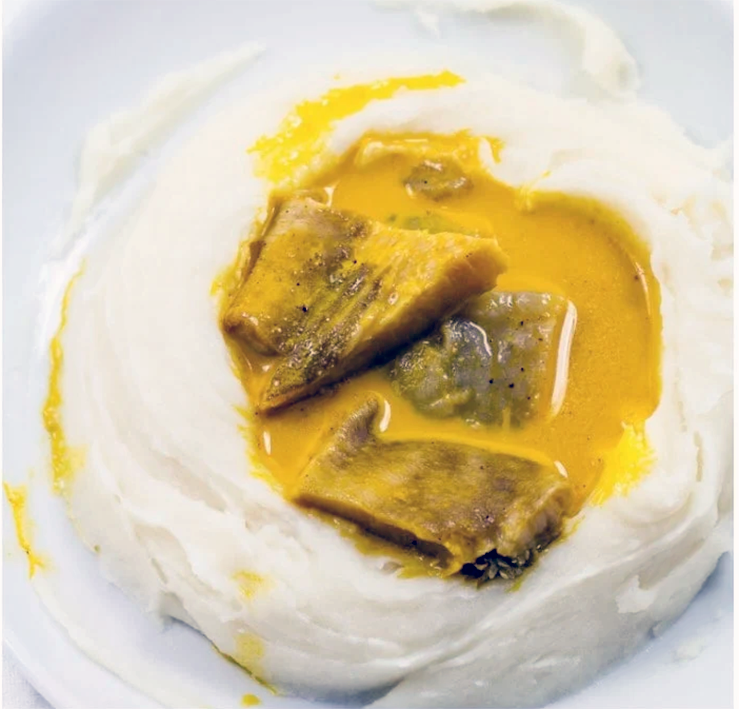yellow soup shown on a base of achu (boiled and mashed cocoyam)