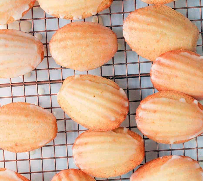 almond madeleines arranged on a cooling rack