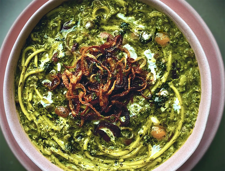 Persian Ash Reshteh, Noodle soup with beans serb in a bowl with crisp-fried onion topping
