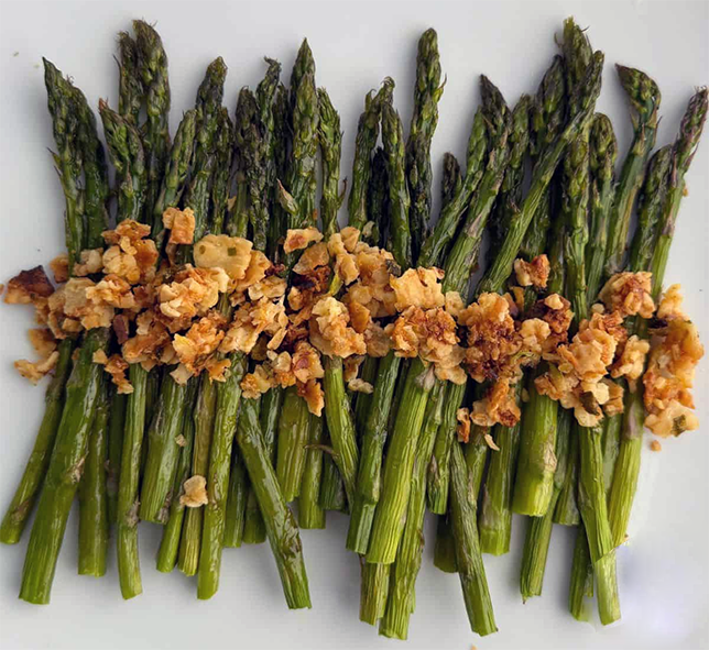 asparagus spears topped with a line of lemon matzo crumble