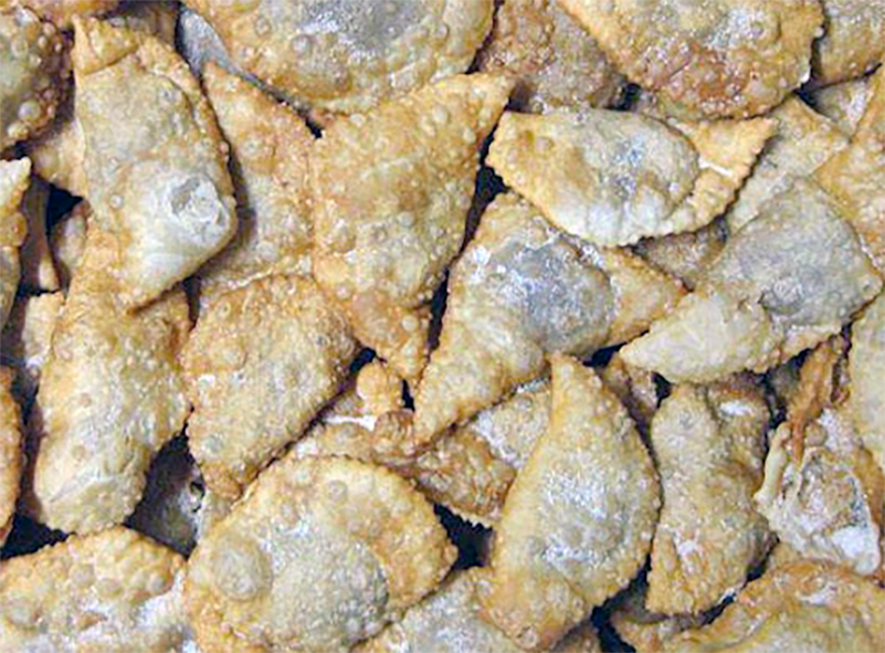 Christmas sweet potato pockets mounded on a metal tray and dusted with icing sugar