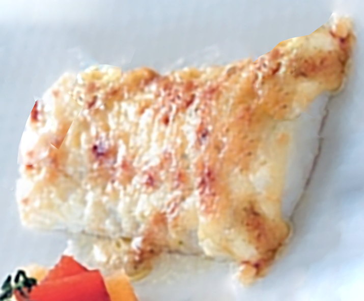 Bacalao con Muselina de Ajo served on a plate next to a tomato salad