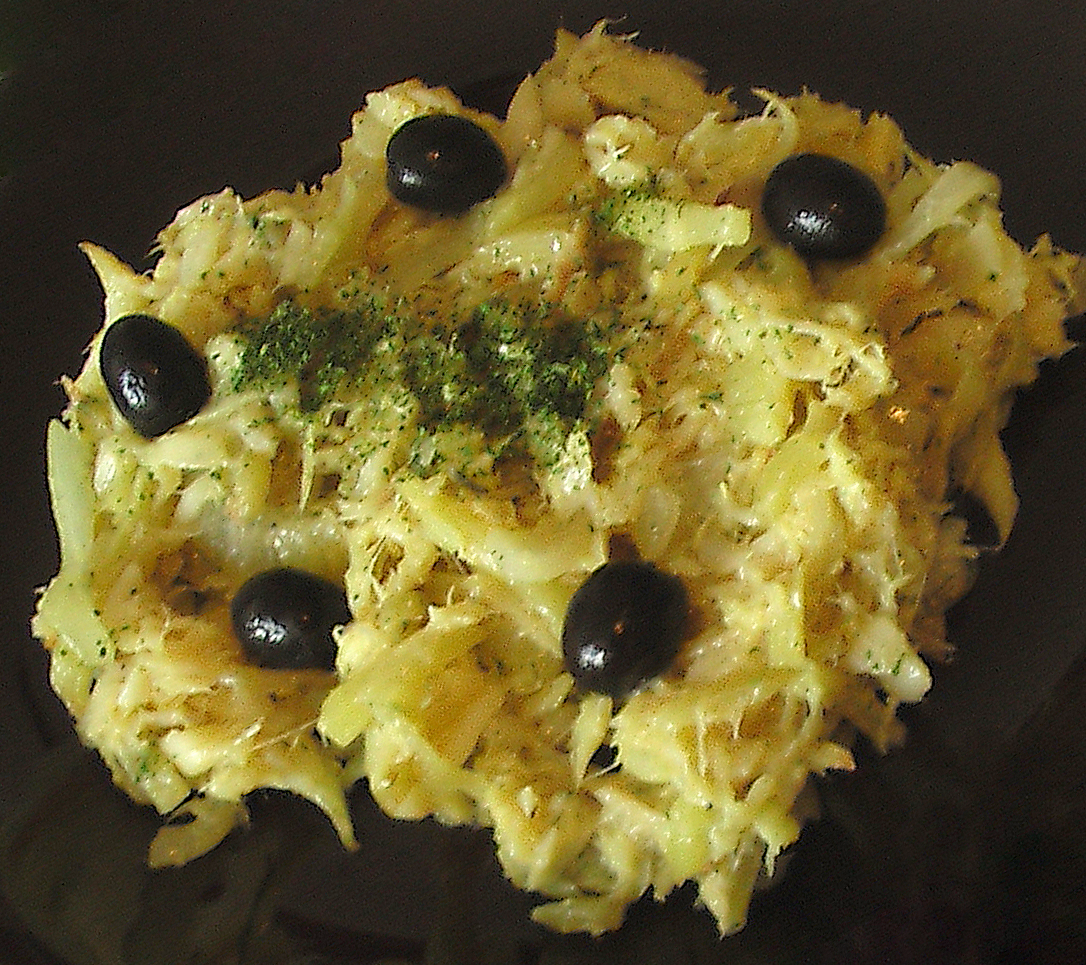bacalhau a bras served on a plate garnished with black olives