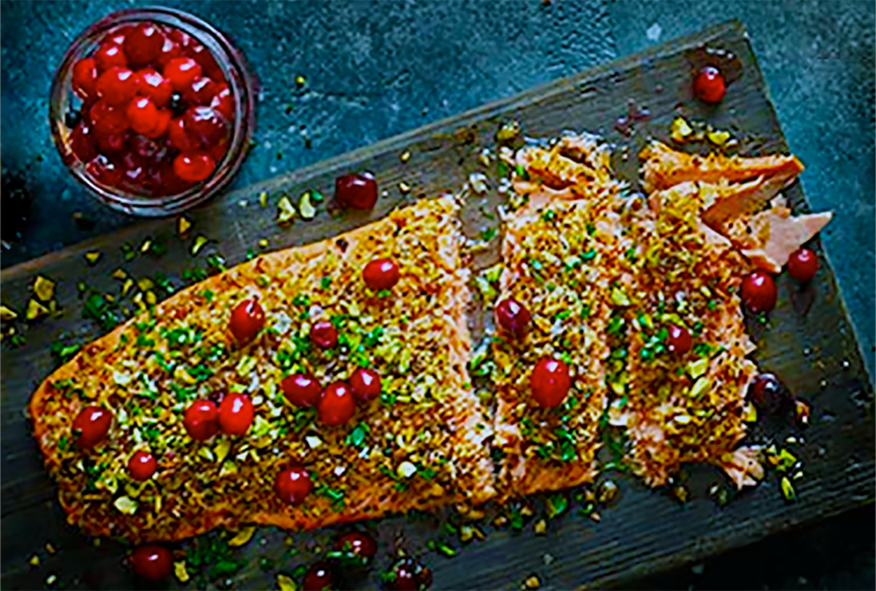 baked salmon fillet topped with Pickled Cranberries, Parsley and Pistachios served on a plank