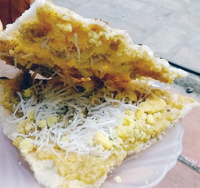 triangular rice crackers served on a plate with a millet porridge, mung bean paste, sugar and grated coconut topping