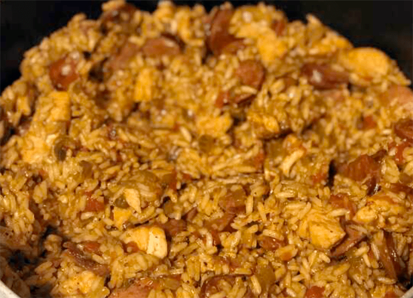 basic cajun jambalaya of pork and sausage with rice in a metal dish