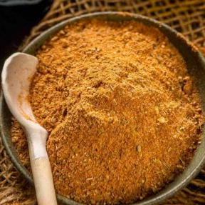 bayou blast seasoning mix mounded in a bowl with a wooden spoon