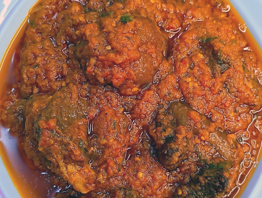 beef with calabash nutmegs cooked in red oil and tomato served in a bowl