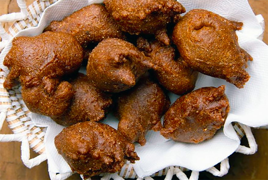 puffed millet doughnuts served on kitchen paper in a grass bowl