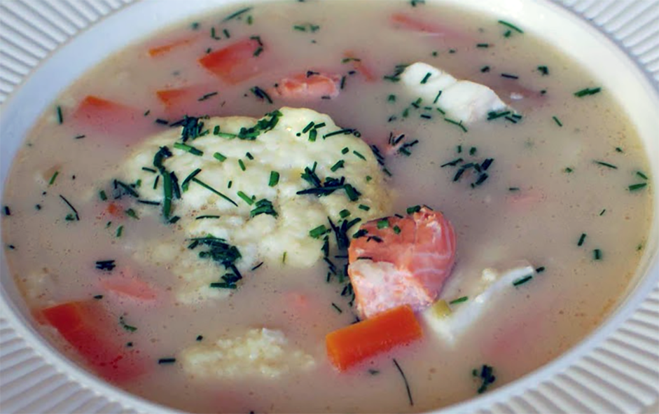 Bergen fish soup garnished with sour cream and snipped chives in a soup dish